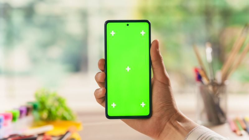 POV View of a Designer Holding a Smartphone with Green Screen Mock Up Display. First Person View of a Man Holding a Device with Isolated Area for App, Software, Website Promotion